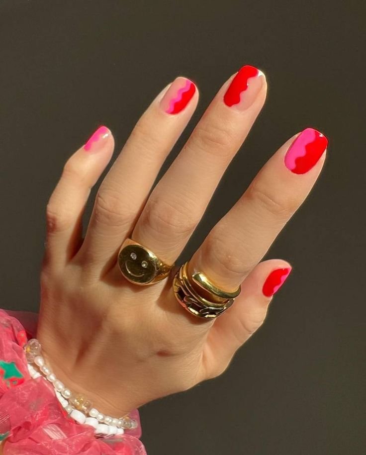 Uñas en colores neón, rosa y rojo, distintos en cada dedo