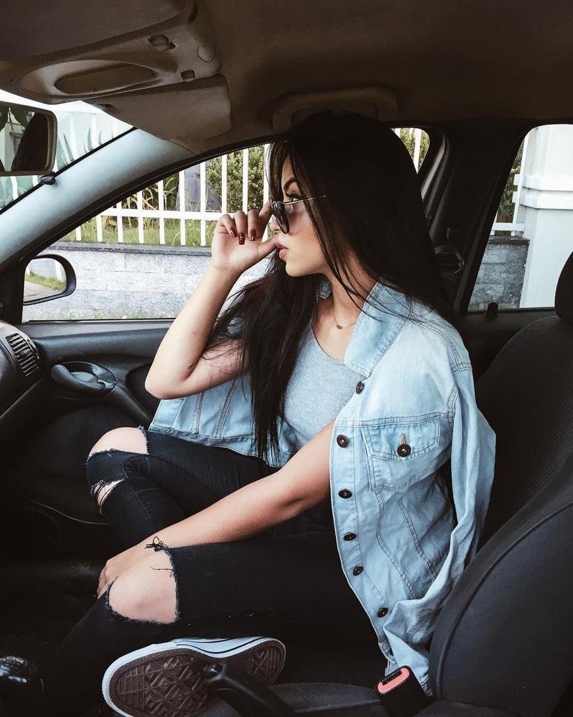 Chica sentada en el coche con chaqueta vaquera