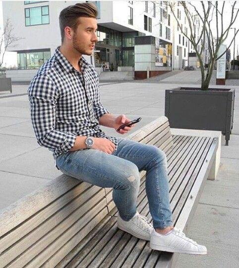 Camisa de cuadros con jeans claros sentado en un banco