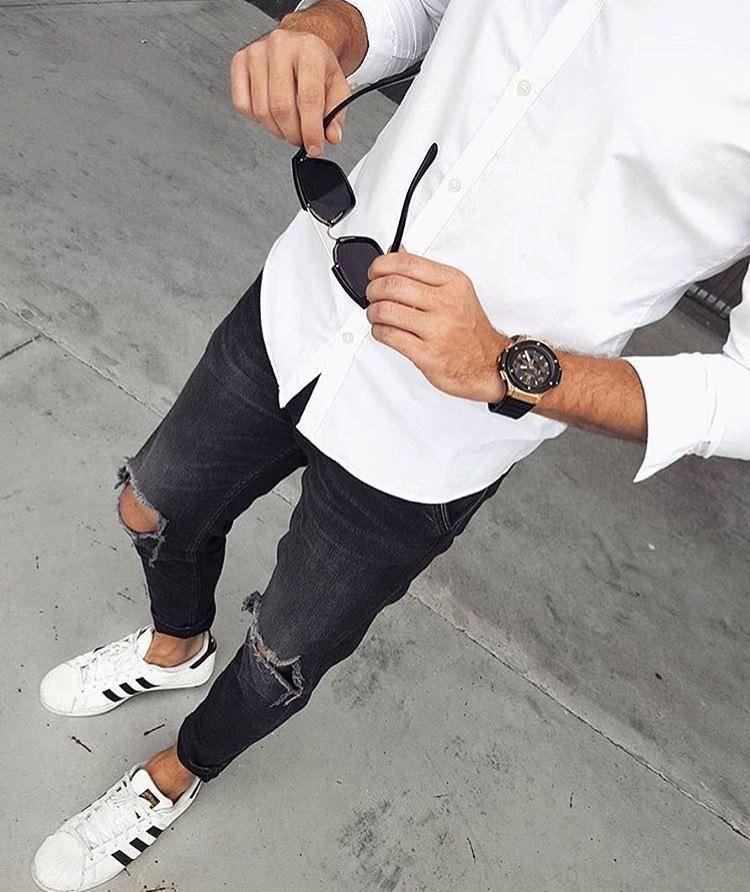 Camisa blanca con jeans negros rotos y tenis