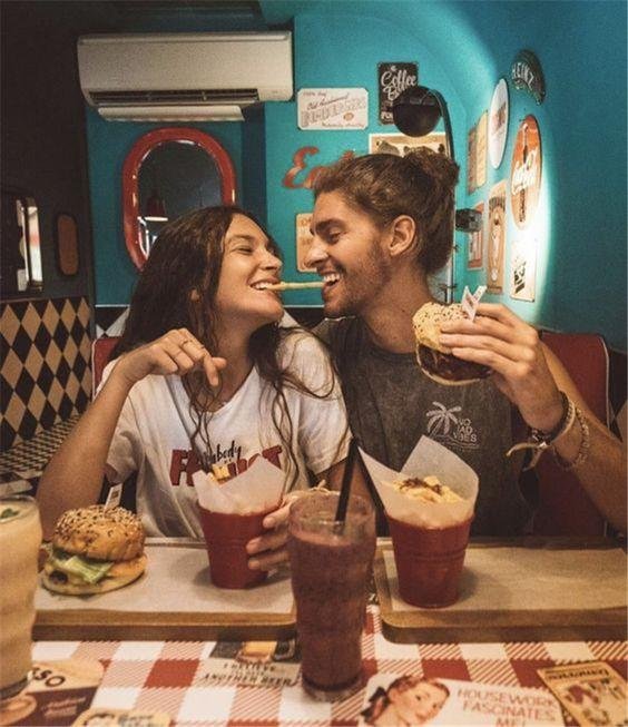 Chica comiendo hamburguesas con un chico