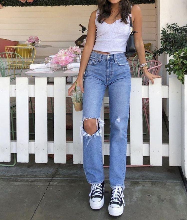 Top blanco con jeans claros y zapatillas de lona