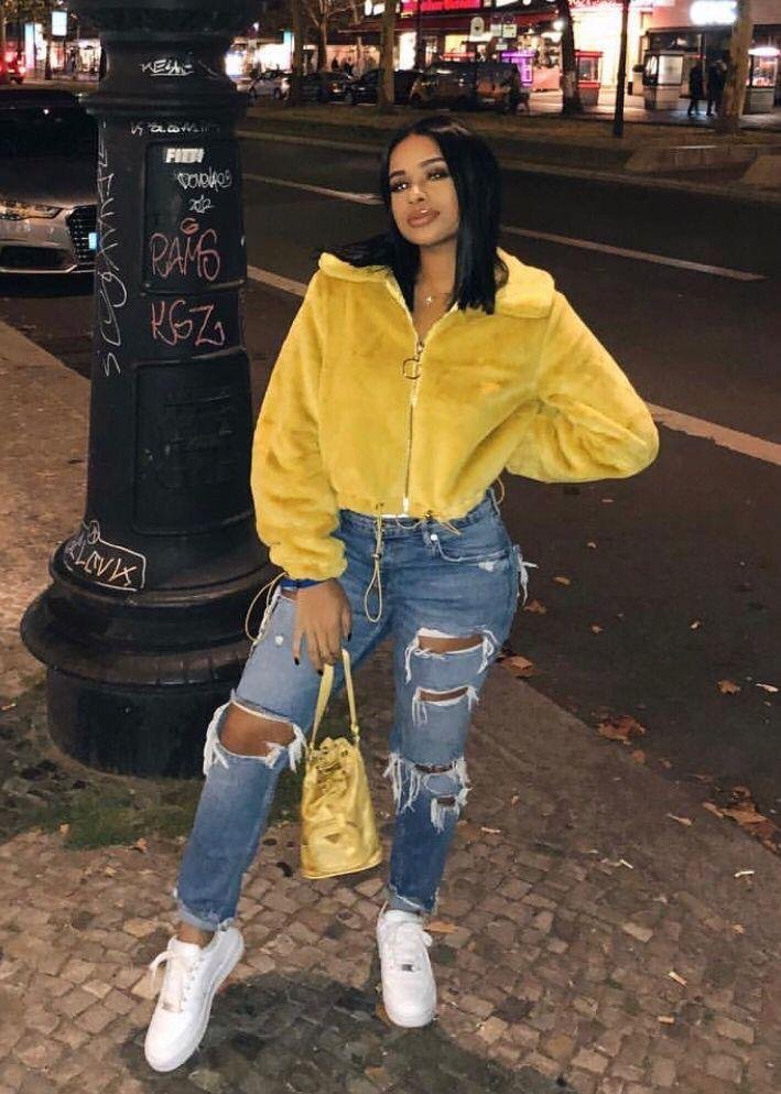 Chaqueta amarilla acolchada con jeans rotos