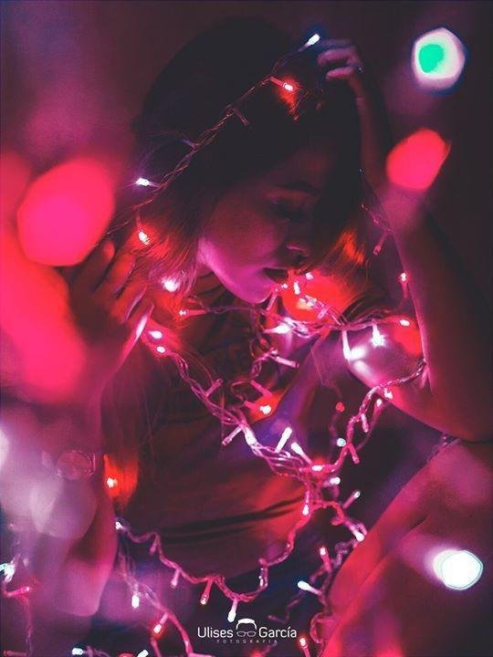 Chica con luces rosas enrolladas en el cuerpo