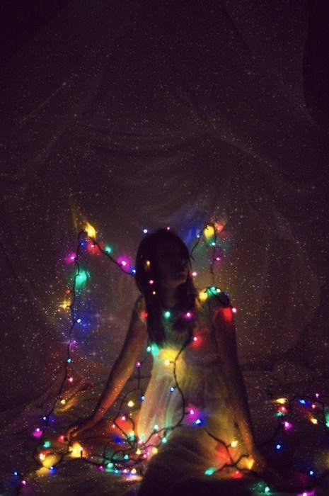 Chica sentada de espaldas con luces de colores