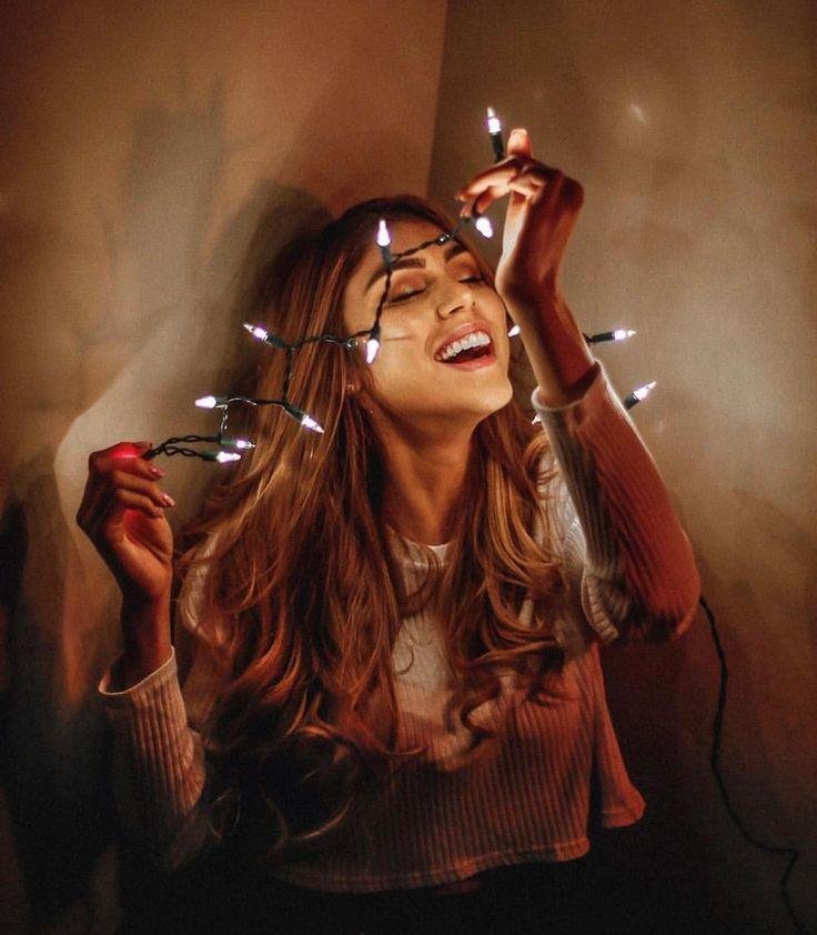 Chica riéndose con luces sostenidas cerca de la cámara