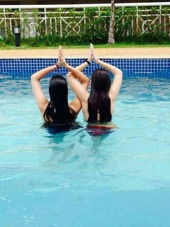 Dos amigas de espaldas formando una figura con los brazos