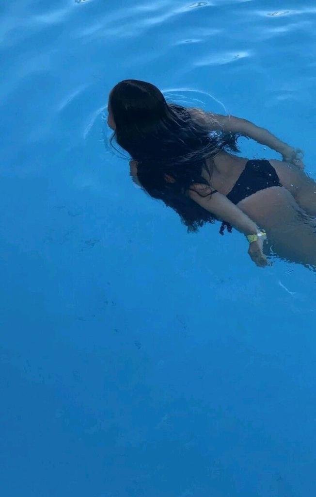 Chica flotando boca abajo en el agua