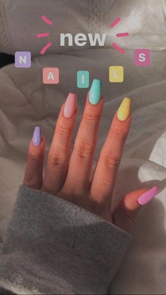 Uñas recién pintadas con letras de adhesivo