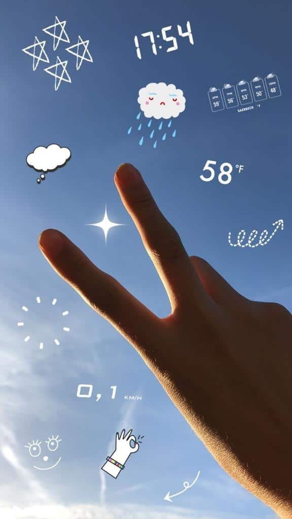 Mano contra el cielo con los adhesivos de hora y clima