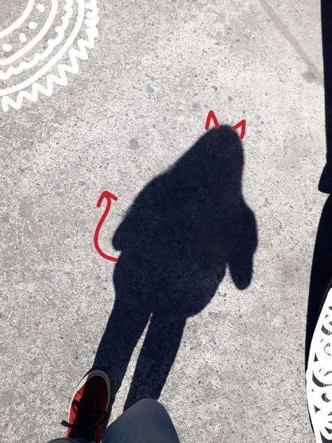 Sombra en el suelo con cuernos dibujados encima