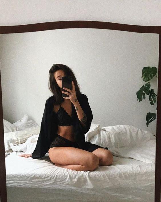 Chica sentada en la cama, foto en el espejo