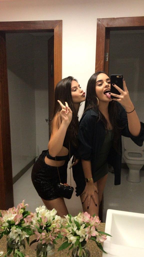 Dos amigas posando en el espejo del baño