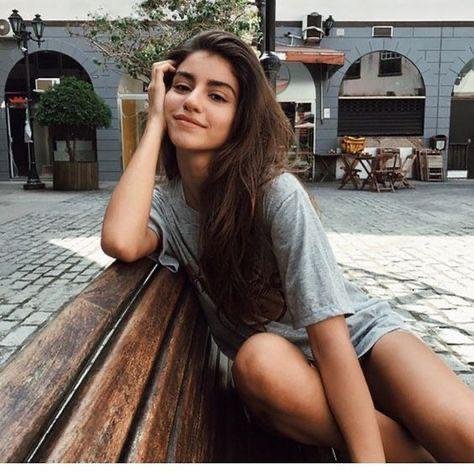 Chica sentada en un banco con la mano en la cara