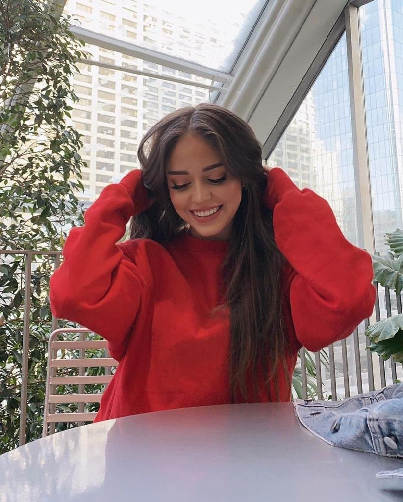 Chica con las manos en el pelo y jersey rojo