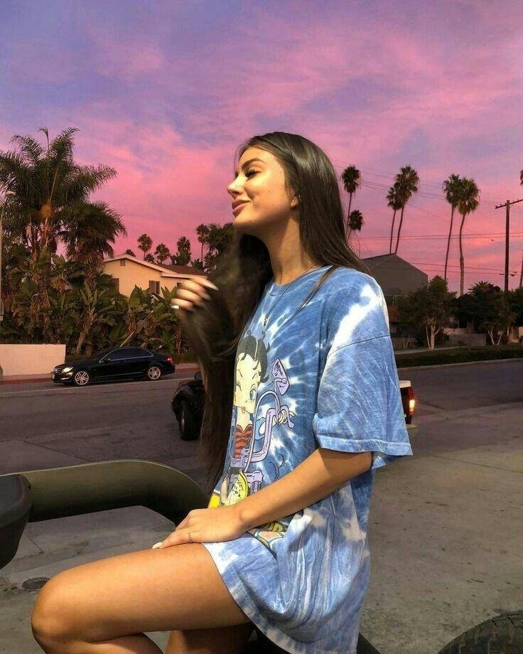 Chica sentada en el bordillo al atardecer