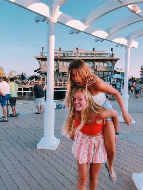 Una amiga a caballito en un muelle de madera
