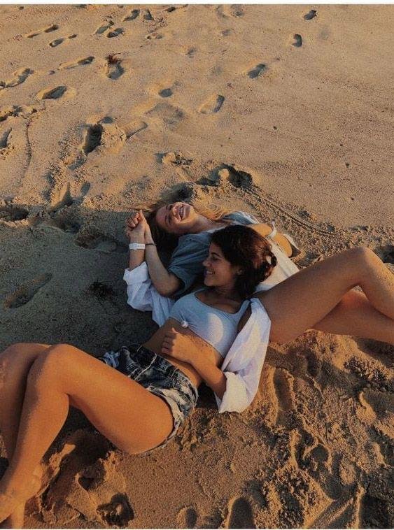 Dos amigas tumbadas en la arena de la playa