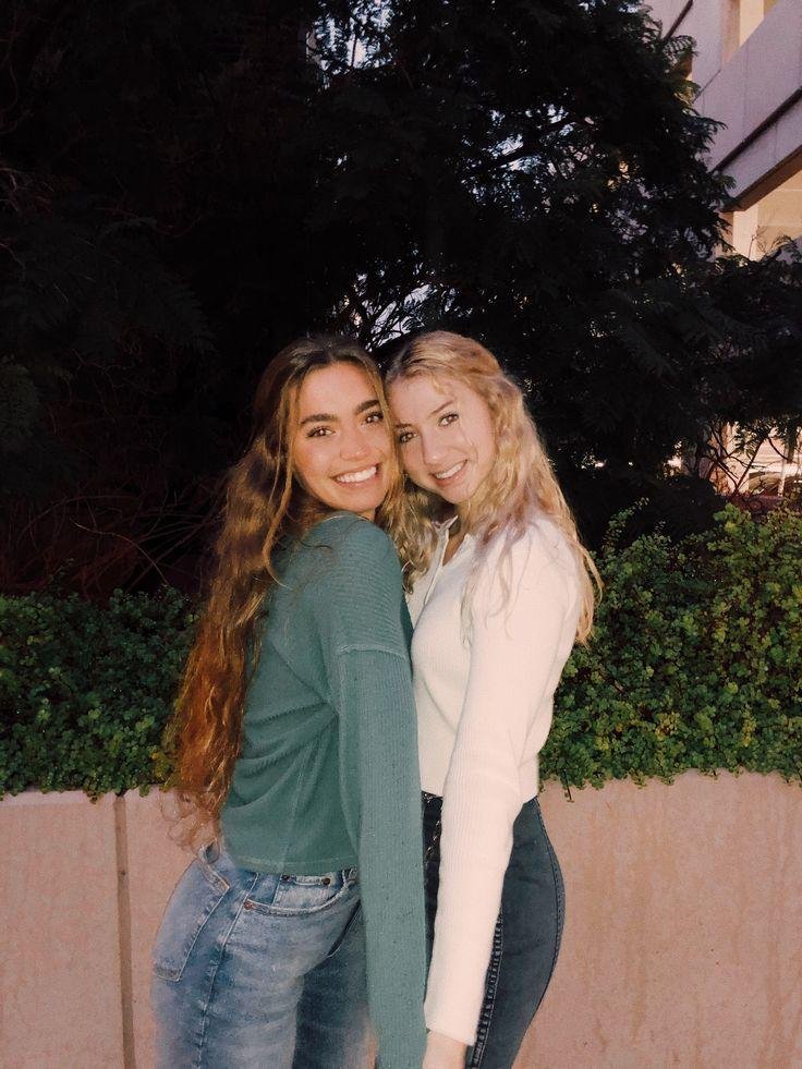 Dos amigas abrazadas de noche al aire libre