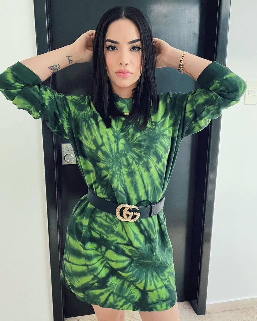 Chica con vestido verde tie dye apoyada en una puerta