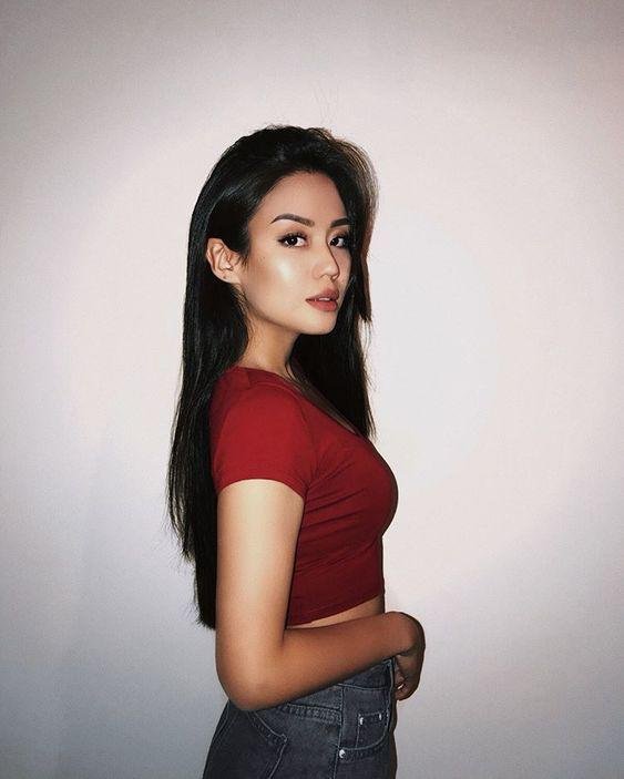 Retrato de perfil con camiseta roja y fondo liso