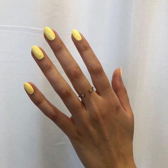 Uñas en amarillo pastel de forma redondeada