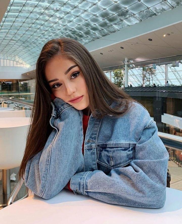 Chica apoyada en una mesa con chaqueta vaquera