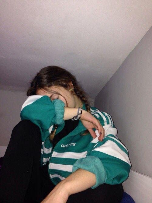 Chica tapándose la cara con la manga de la sudadera