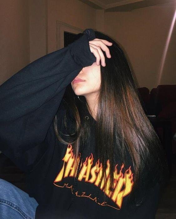 Chica tapándose la cara con una sudadera