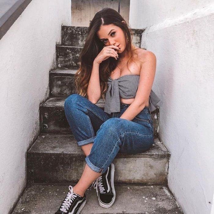 Chica sentada en unas escaleras con jeans