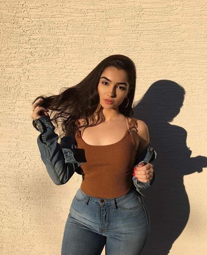 Chica de pie contra una pared con sombra marcada