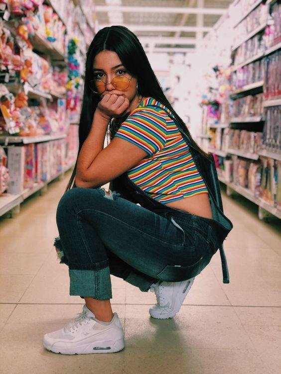 Chica agachada en el pasillo de una tienda
