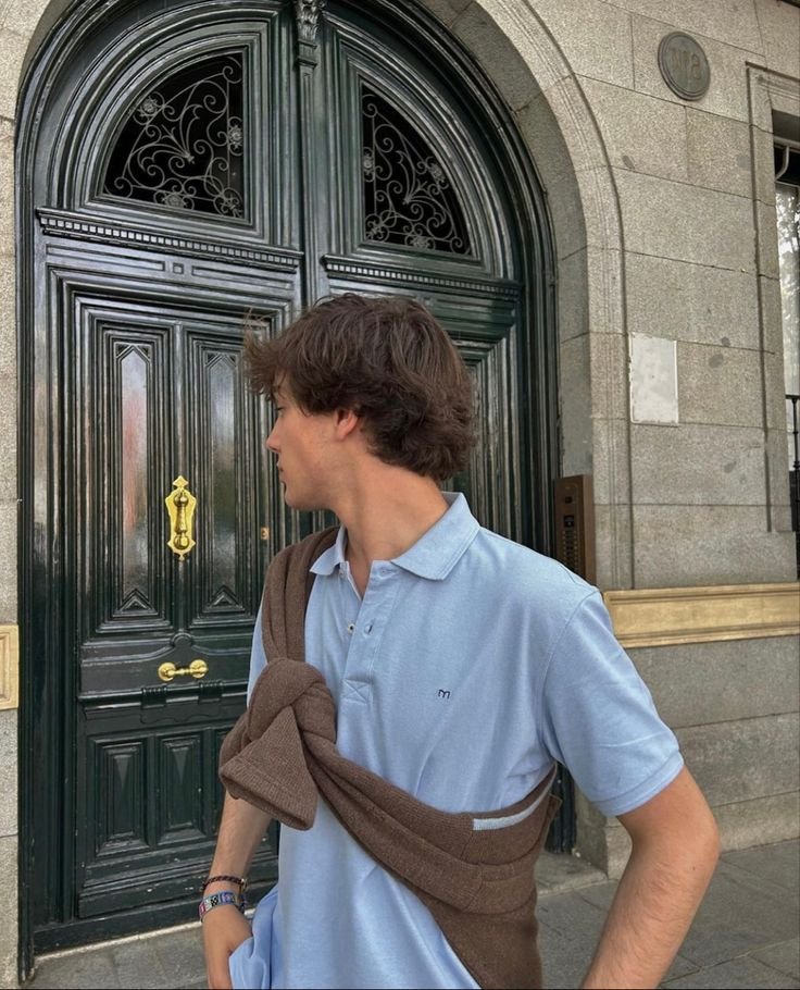 Chico de perfil frente a una puerta antigua