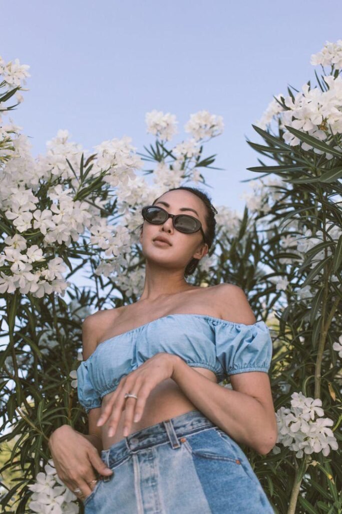 Chica entre flores blancas con gafas de sol