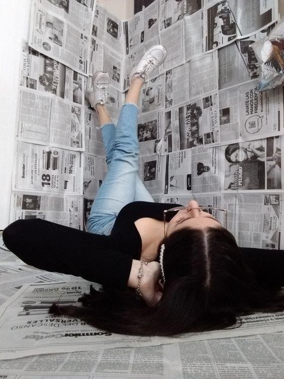 Chica tumbada en el suelo con las piernas apoyadas en la pared