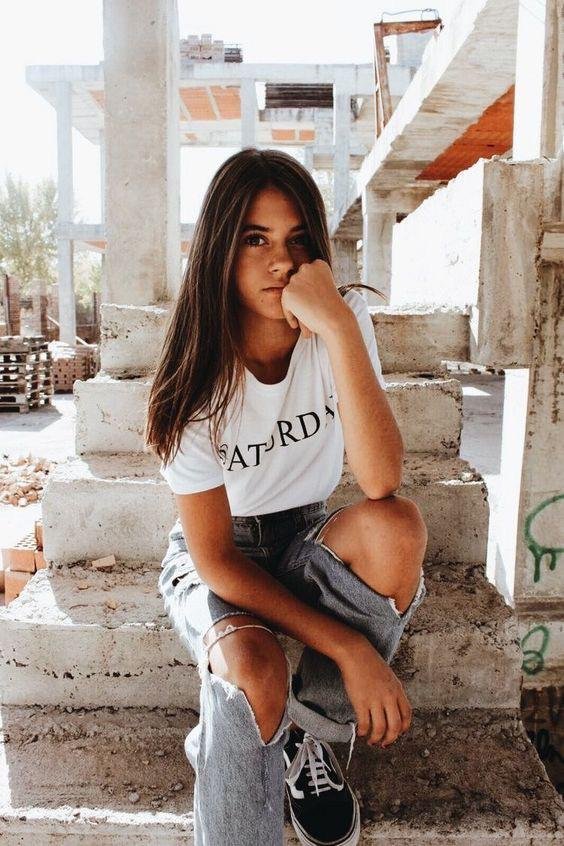 Chica agachada en unas escaleras