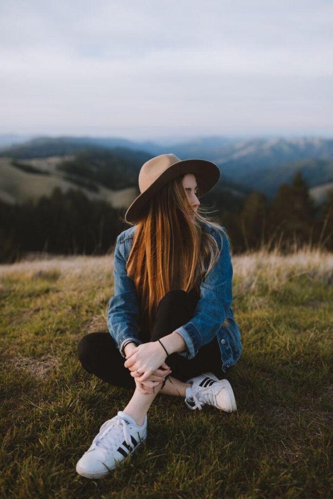 Chica sentada en el campo con sombrero