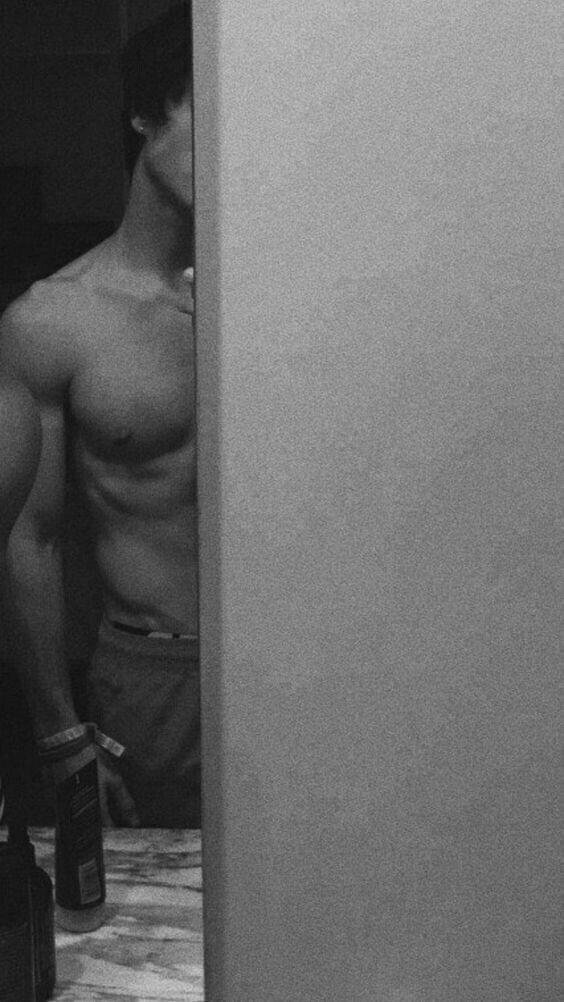 Foto en blanco y negro de espaldas apoyado en una pared