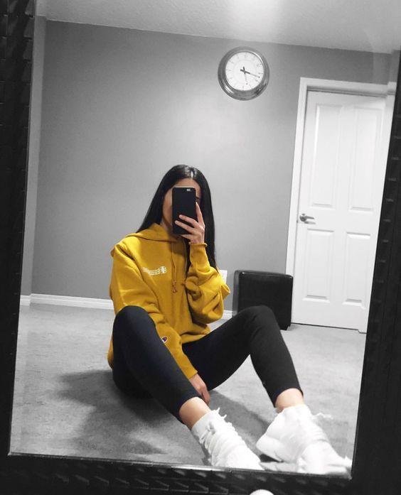 Chica sentada en el suelo con sudadera amarilla