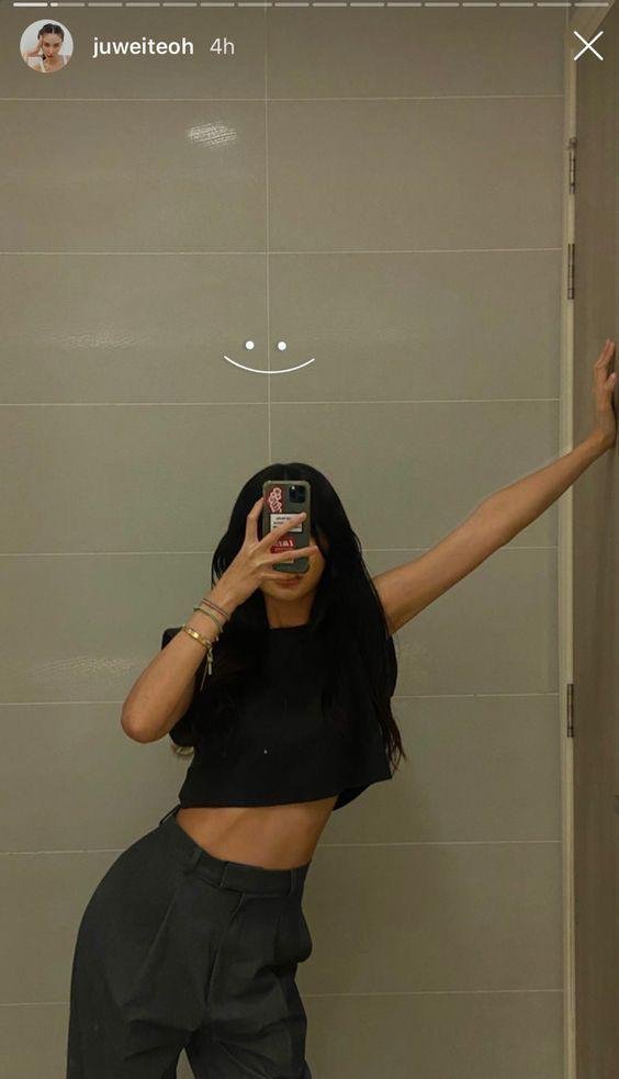 Pose con el brazo estirado apoyado en la pared y crop top