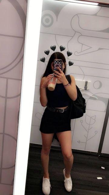 Cuerpo entero de pie con top negro y shorts