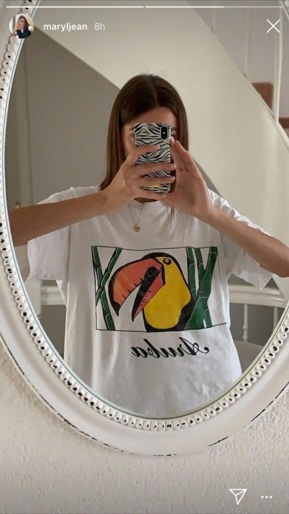 Foto en un espejo ovalado con camiseta blanca estampada