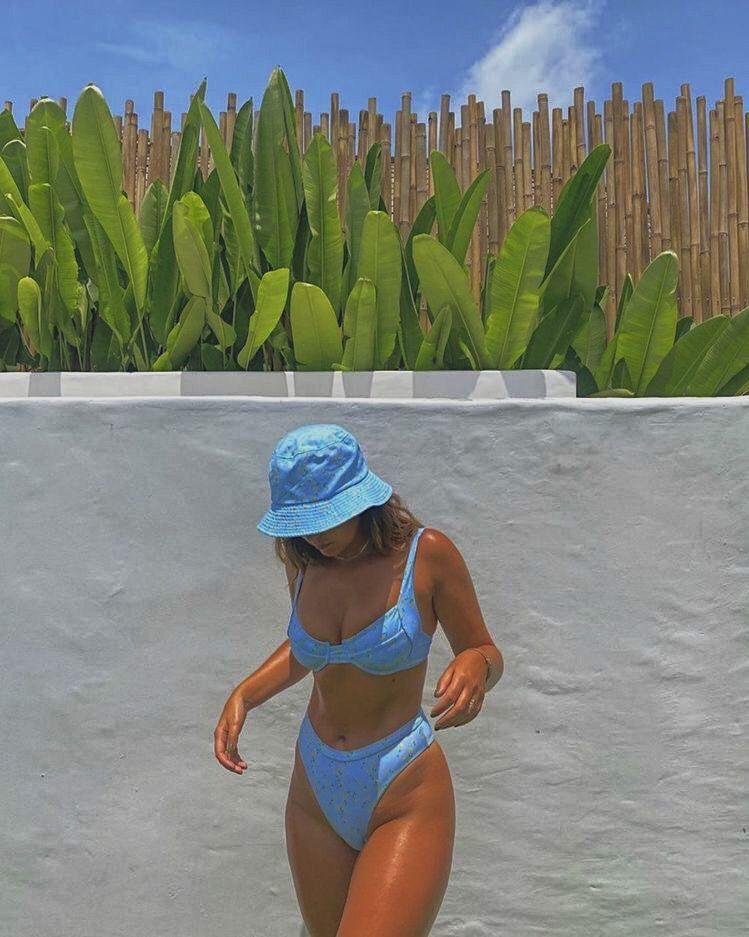 Chica caminando junto a la piscina con gorro bucket
