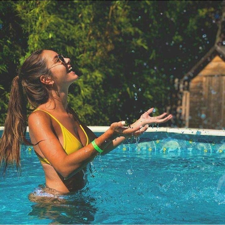 Chica salpicando agua dentro de la piscina