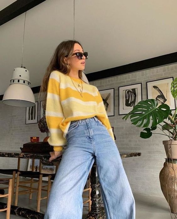 Jersey de rayas amarillo con jeans anchos claros