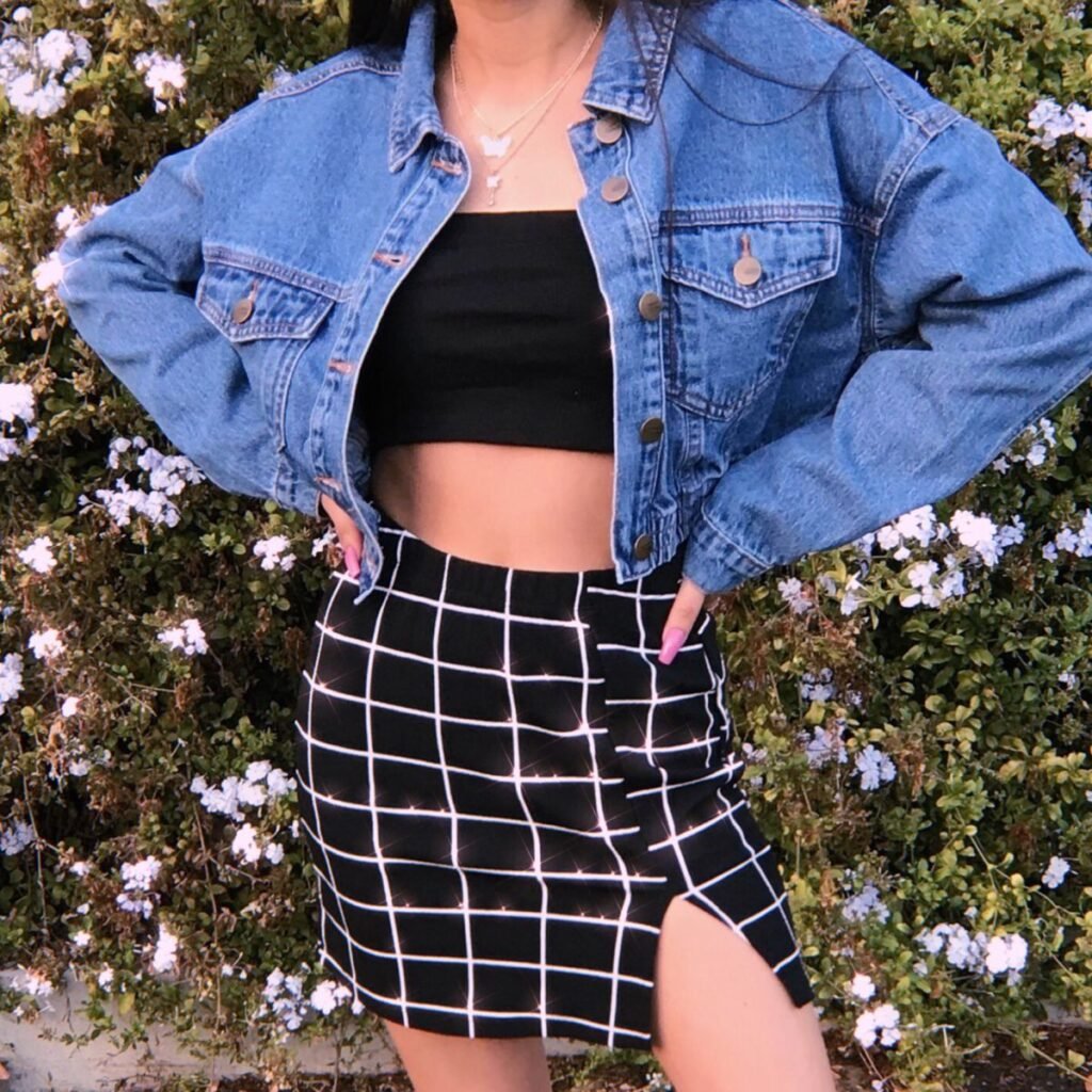 Chaqueta vaquera con top negro y falda de cuadros