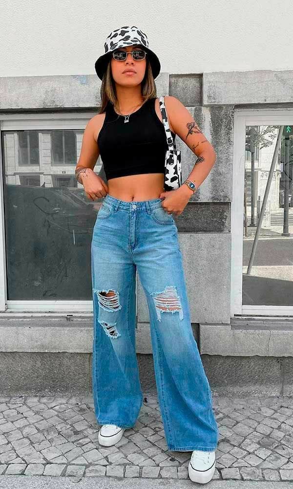 Top negro con jeans anchos rotos y bucket hat