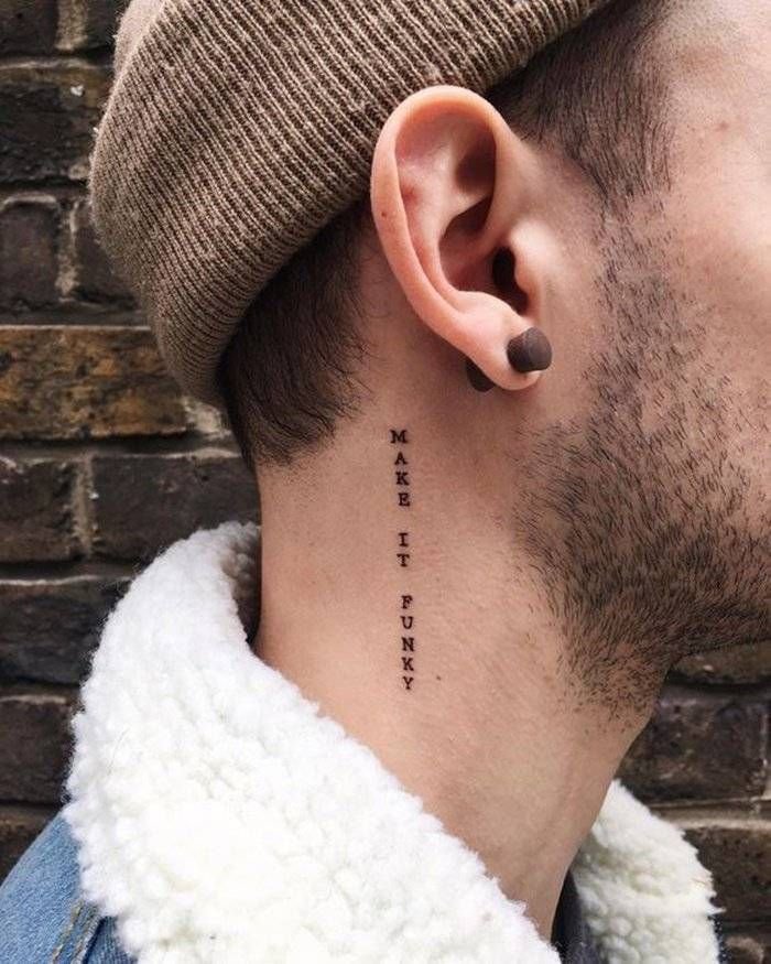 Frase en letras mayúsculas tatuada en vertical en el cuello