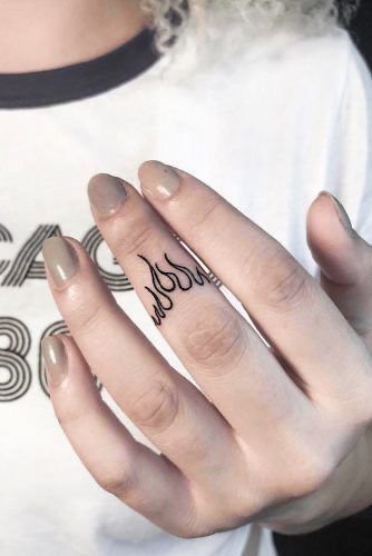 Letras pequeñas tatuadas en los dedos