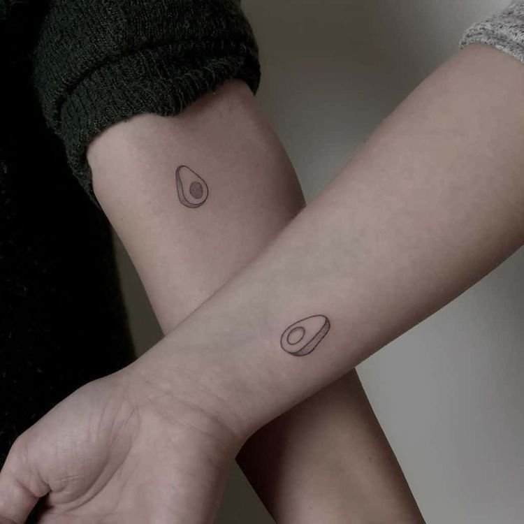 Aguacates a juego tatuados en dos antebrazos